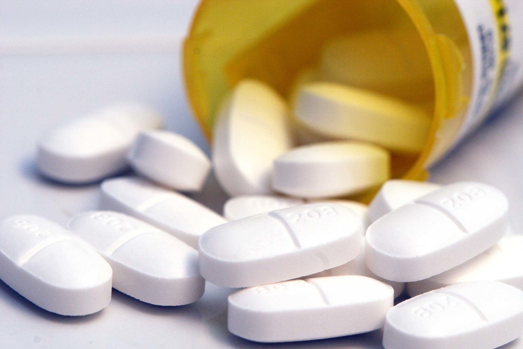 White pills falling out of a medication bottle